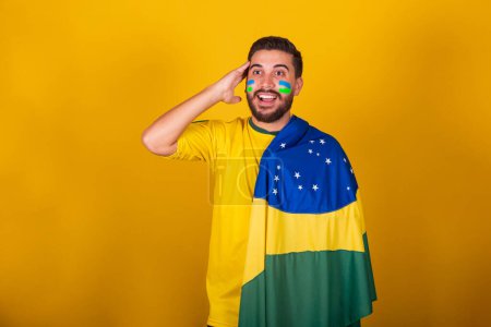 Foto de Hombre brasileño, latinoamericano, animando a Brasil, en la copa del mundo 2022, patriota, nacionalista, ansioso, atento, mirando al campo, sorprendido, expresión de atención y suspenso, feliz - Imagen libre de derechos