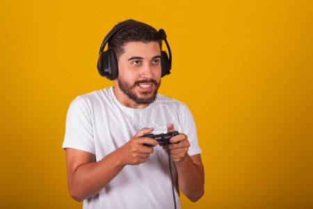 Foto de Feliz brasileño latinoamericano con auriculares y controlador de videojuegos jugando, emociones, disfrutando. - Imagen libre de derechos