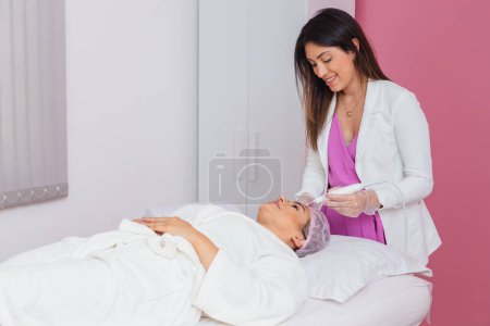 Photo for Beautician doctor, woman applying facial plasma jet on patient, Application of aesthetic procedure, rejuvenation. - Royalty Free Image