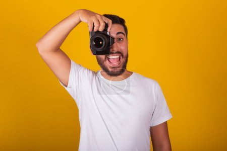 Téléchargez les photos : Brésilien latino-américain, heureux, tenant un appareil photo numérique, concept de photographie, photographe, profession, passe-temps, passe-temps. - en image libre de droit