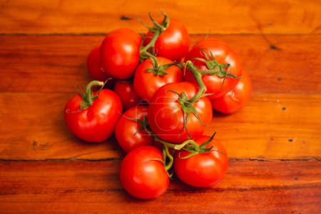 Photo for Heap of tomatoes on wooden table - Royalty Free Image