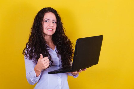 Photo for Caucasian, Brazilian woman holding notebook, laptop. informatics concept. remote work. connectivity. thumb up, approval. confirmation. - Royalty Free Image