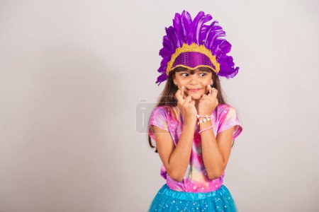 Photo for Beautiful Brazilian girl, child, dressed for carnival in Brazil. cheering hard, wishing, lucky sign. - Royalty Free Image