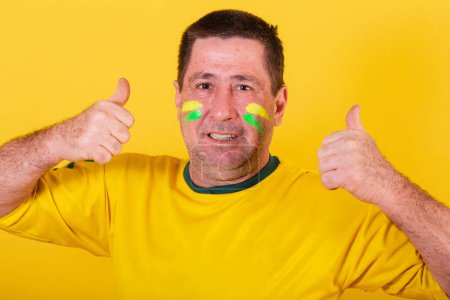 Téléchargez les photos : Homme adulte, fan de football brésilien, comme signe avec les mains. approbation, affirmative. gros plan photo - en image libre de droit