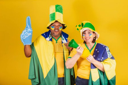 Photo for Couple, red-haired woman and black man, Brazilian soccer fans. dresses for world. - Royalty Free Image