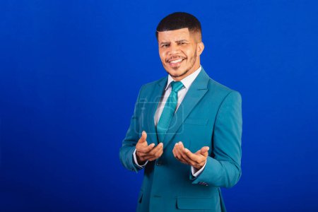 Foto de Hombre negro brasileño, vestido con traje y corbata azul. hombre de negocios. invitando con las manos, llamando - Imagen libre de derechos