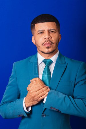 Téléchargez les photos : Homme noir brésilien, vêtu d'un costume et cravate bleue. homme d'affaires. avec bras croisés, visage sérieux. - en image libre de droit