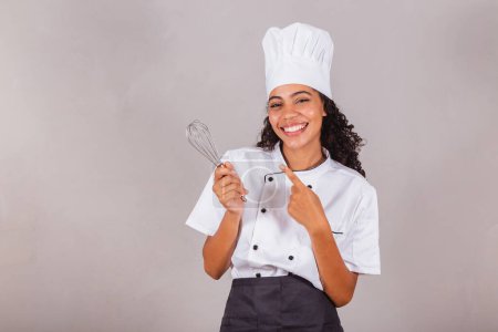 Téléchargez les photos : Jeune femme brésilienne noire, cuisinière, chef cuisinier. tenue de fue, préparation de bonbons. - en image libre de droit