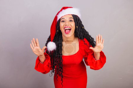 Photo for Brazilian black woman, wearing christmas clothes, merry christmas, smiling, wow, amazing, surprised, unbelievable. - Royalty Free Image
