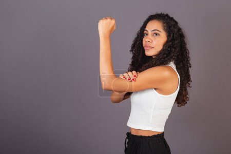 Photo for Young black Brazilian woman, with raised and closed fist, militancy, feminism. - Royalty Free Image