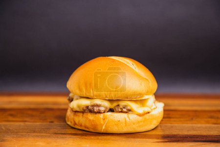 Foto de Deliciosa hamburguesa brasileña tradicional, X hamburguesa, carne y queso. sobre tabla de madera. - Imagen libre de derechos