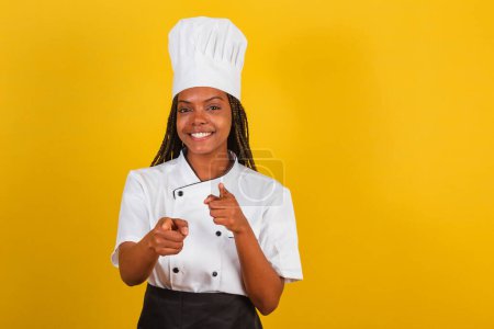 Photo for Young Afro-Brazilian woman, chef, pointing at screen, choosing you - Royalty Free Image