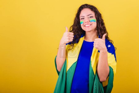 Photo for Woman soccer fan, fan of brazil, world cup, looking at camera with hand on chin. interactive photo. - Royalty Free Image