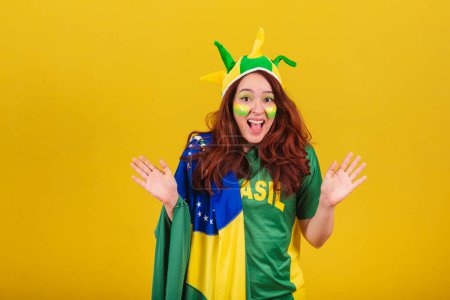 Photo for Caucasian woman, redhead, soccer fan from Brazil, wow, amazing, amazed, unbelievable. - Royalty Free Image