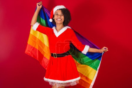 Foto de Hermosa mujer brasileña negro, vestido como santa claus, mama claus, con la bandera lgbt diversidad, gays y lesbianas - Imagen libre de derechos