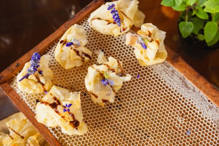 Foto de Bolsitas de hojaldre al horno con queso brie y miel, snack gourmet buffet. - Imagen libre de derechos