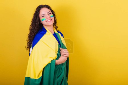 Photo for Woman soccer fan, fan of brazil, world cup, using flag as mantle or cape. - Royalty Free Image