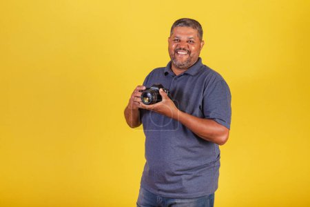 Photo for Brazilian black man, adult holding photo camera, photography hobby, photographer. - Royalty Free Image
