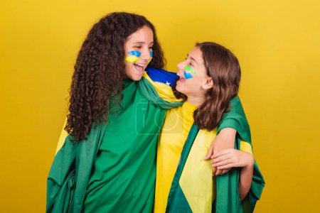 Photo for Friends cheering from Brazil, soccer fans hugging, smiling and cheering for a soccer game. World Cup. Olympics. - Royalty Free Image