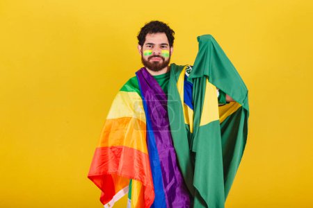 Foto de Hombre caucásico con barba, brasileño, ventilador de fútbol de Brasil, con bandera lgbt - Imagen libre de derechos