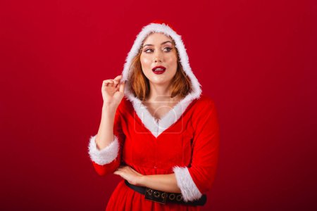 Téléchargez les photos : Belle femme rousse brésilienne, vêtue de vêtements de Noël, le Père Noël. chapeau de port. - en image libre de droit