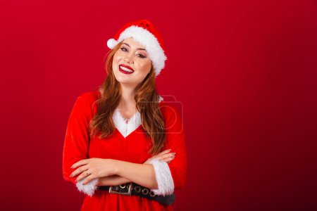 Téléchargez les photos : Belle femme rousse brésilienne, vêtue de vêtements de Noël, le Père Noël. bras croisés. - en image libre de droit