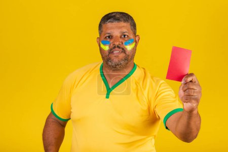 Téléchargez les photos : Homme noir brésilien, fan de football brésilien. montrant le carton rouge. manque - en image libre de droit