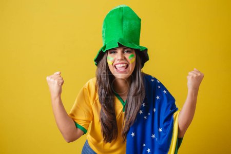 Foto de Mujer partidaria de Brasil, copa del mundo 2022, vistiendo el típico traje de abanico para ir al juego, bandera de Brasil y sombrero verde. de fiesta. Gritando meta. - Imagen libre de derechos