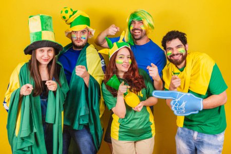 Foto de Grupo de amigos, aficionados al fútbol de Brasil, con bandera de Brasil, apuntando a la cámara, eligiéndote. - Imagen libre de derechos
