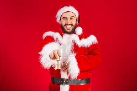 Photo for Brazilian man, dressed in santa claus clothes, holding christmas bell. - Royalty Free Image