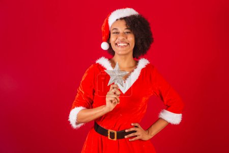 Téléchargez les photos : Belle femme brésilienne noire, habillée en Père Noël claus, maman claus, tenant étoile de Noël - en image libre de droit