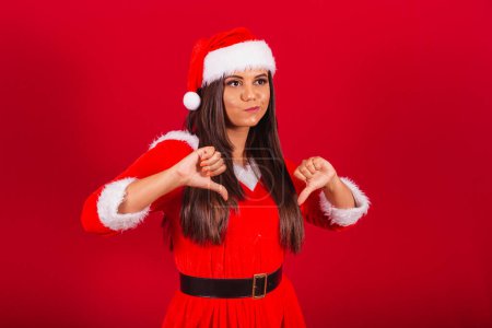 Photo for Beautiful Brazilian woman dressed in Christmas clothes, Santa Claus. dislike, negative. - Royalty Free Image
