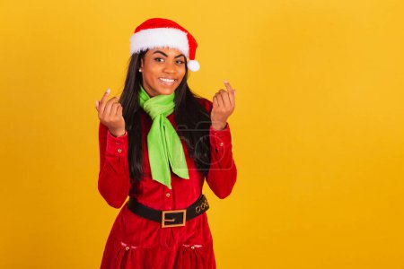 Téléchargez les photos : Belle femme brésilienne noire, vêtue de vêtements de Noël, Père Noël claus, invitant avec les mains, venez. - en image libre de droit