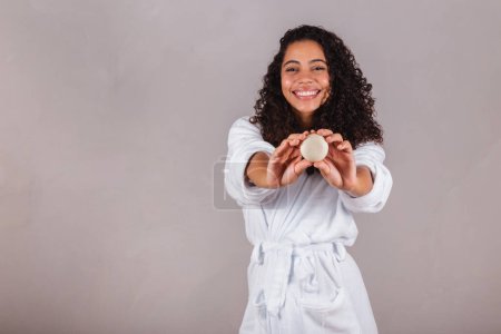 Photo for Brazilian black woman, wearing bathrobe and towel. vegan products for beauty and skin and hair care. soaps, Spa, self care. welfare. - Royalty Free Image