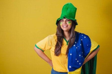 Photo for Woman supporter of Brazil, world cup 2022, wearing typical fan outfit to go to the game, brazil flag and green hat. - Royalty Free Image