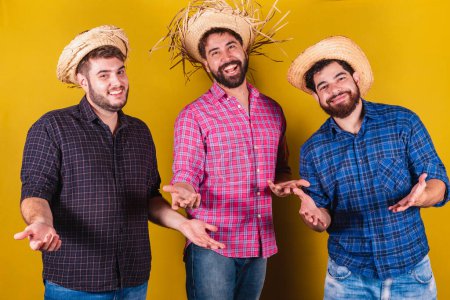 Photo for Three friends wearing typical clothes for the Festa Junina. Welcome. - Royalty Free Image