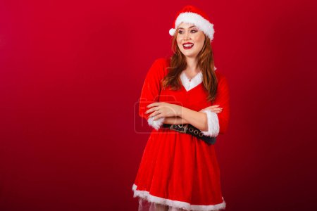 Téléchargez les photos : Belle femme rousse brésilienne, vêtue de vêtements de Noël, le Père Noël. bras croisés. - en image libre de droit