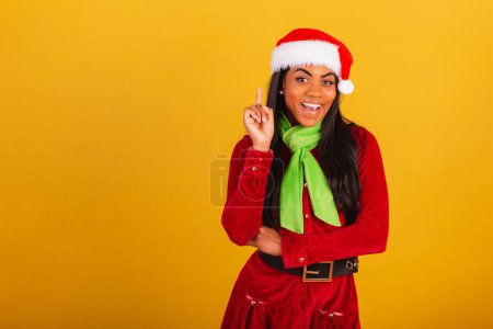 Photo for Beautiful black Brazilian woman, dressed in Christmas clothes, santa claus, thought idea. - Royalty Free Image