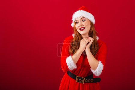 Photo for Beautiful Brazilian red-haired woman, dressed in Christmas clothes, Santa Claus. looking at photo, hopeful and cute. - Royalty Free Image