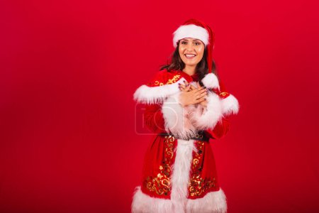 Foto de Mujer brasileña vestida con ropa de Navidad, Santa Claus. oración, manos en el centro, espiritualidad, esperanza. - Imagen libre de derechos