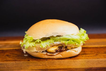 Foto de Deliciosa hamburguesa tradicional brasileña, ensalada de hamburguesas X, carne y queso y ensalada. sobre tabla de madera. - Imagen libre de derechos