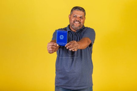 Téléchargez les photos : Homme noir brésilien, adulte avec carte de travail et sécurité sociale, retraite. marché du travail. - en image libre de droit