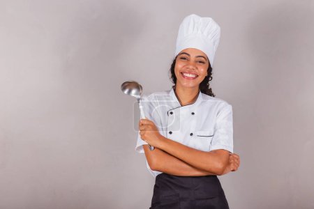 Téléchargez les photos : Jeune Brésilienne noire, cuisinière. Poche de cuisine pour préparer bouillons et soupes. - en image libre de droit