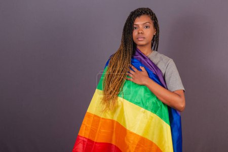 Téléchargez les photos : Jeune femme afro-brésilienne, drapeau LGBT, LGBTQ, bisexuelle. diversité. Lesbienne. Main sur la poitrine pour montrer vos valeurs pour la cause - en image libre de droit