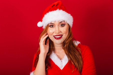 Foto de Hermosa brasileña pelirroja, vestida con ropa de Navidad, Santa Claus. primer plano de la cara de la modelo. - Imagen libre de derechos