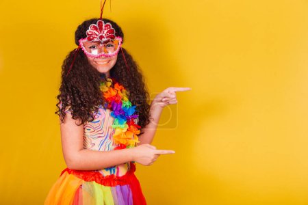 Téléchargez les photos : Caucasienne, fille brésilienne habillée pour le carnaval. accueil, pointage vers le côté, espace négatif, présentation du produit. - en image libre de droit