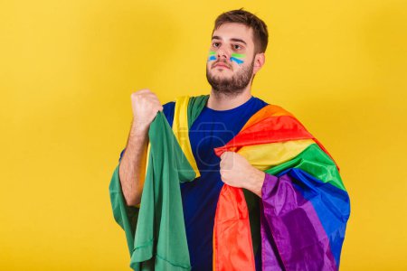 Photo for Brazilian caucasian man, soccer fan from Brazil, holding LGBT flag, gender equality concept, lgbt pride, confident. diversity. Sexuality. - Royalty Free Image