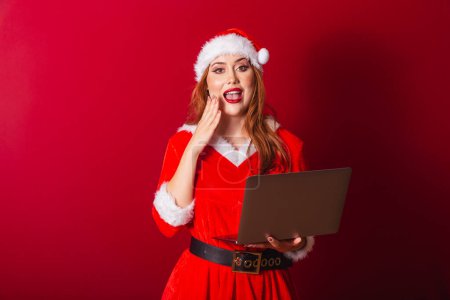 Photo for Beautiful Brazilian red-haired woman, dressed in Christmas clothes, Santa Claus. holding notebook. Wow, incredible, unbelievable. - Royalty Free Image