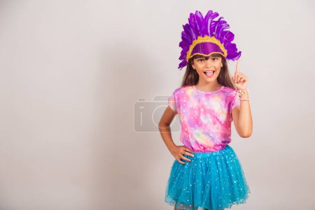 Téléchargez les photos : Belle fille brésilienne, enfant, habillée pour le carnaval au Brésil. doigt levé, idée, réponse, pensée. - en image libre de droit