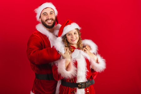 Foto de Pareja brasileña, vestida con ropa de Navidad, Santa Claus, abrazos - Imagen libre de derechos